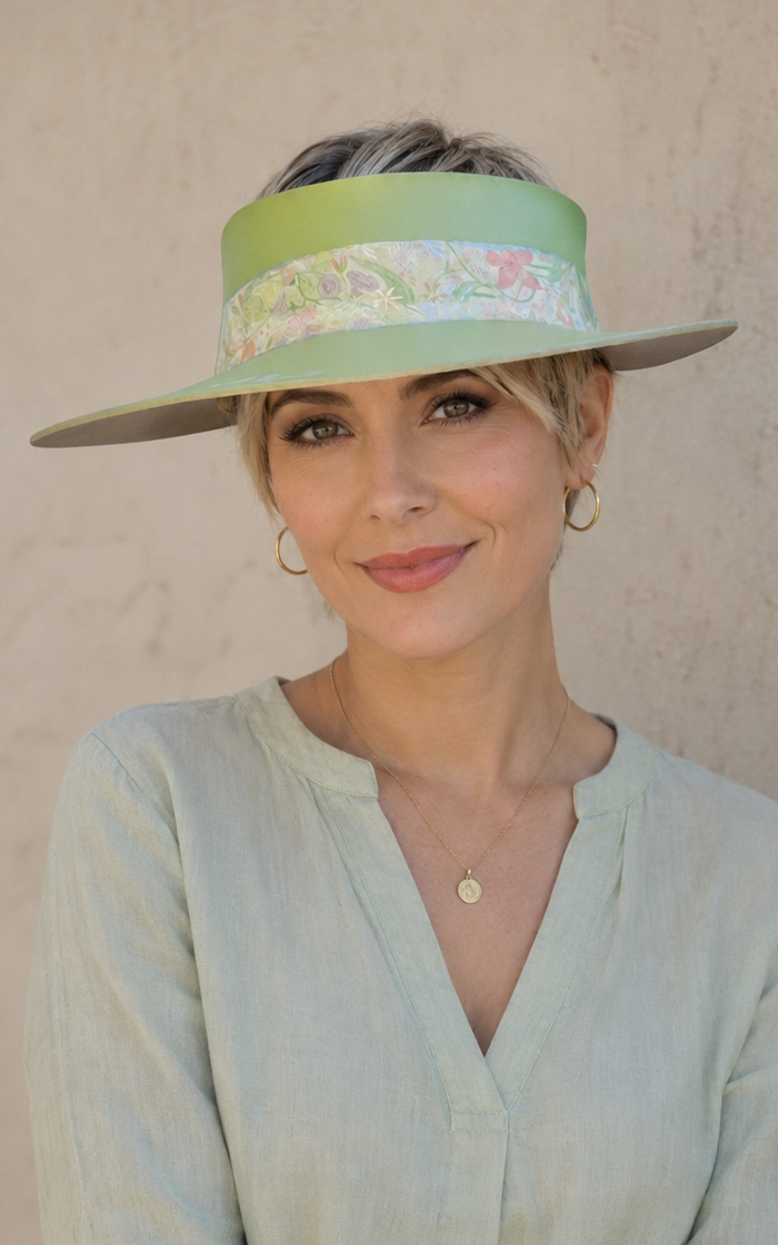 Woman wearing a light green hat and shirt against a plain background