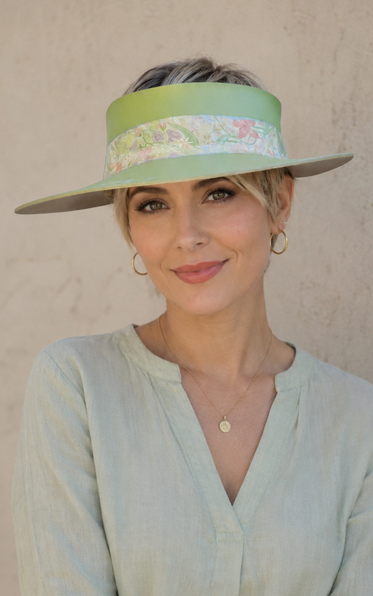 Woman wearing a light green hat and shirt against a plain background