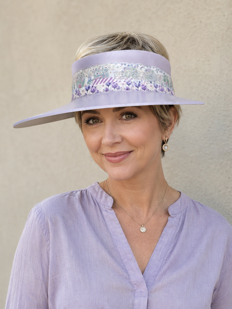 Woman wearing a light purple visor and shirt against a beige background