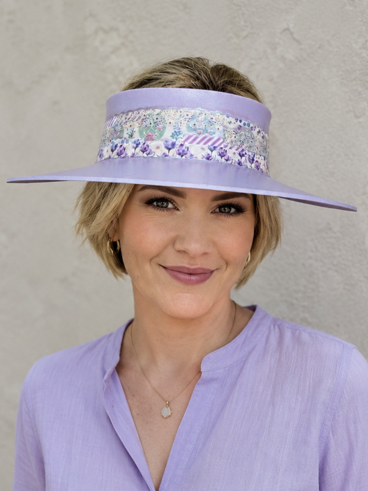 Woman wearing a purple visor with sequin embellishments against a plain background