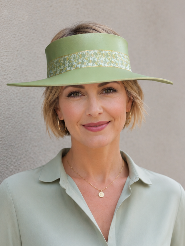 Woman wearing a green visor and matching shirt against a plain background