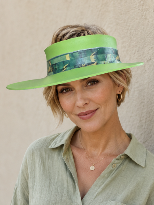 Woman wearing a green visor and green shirt against a beige wall