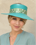 Woman wearing a turquoise hat with a floral band against a beige background