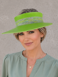 Woman wearing a green visor and light green blouse against a gray background
