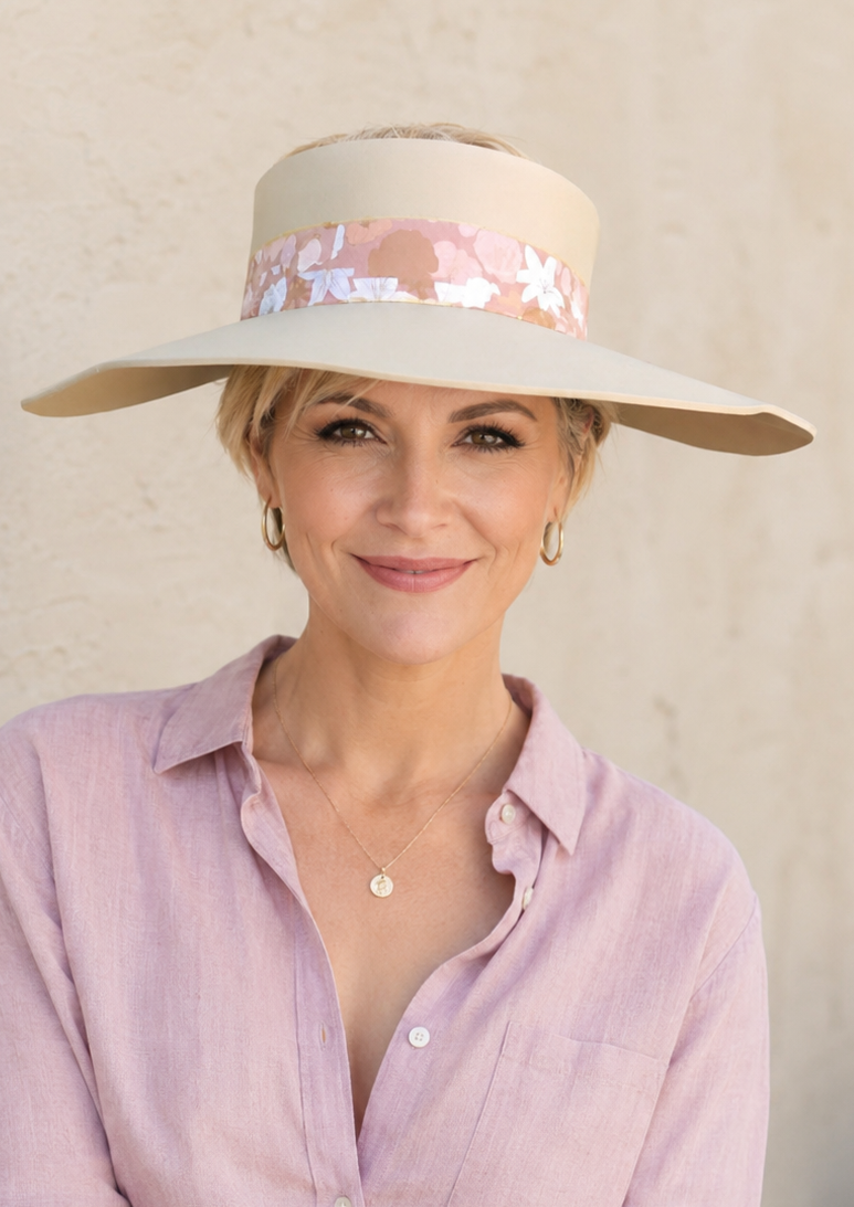 Woman wearing a wide-brimmed hat with a sequin band against a neutral background