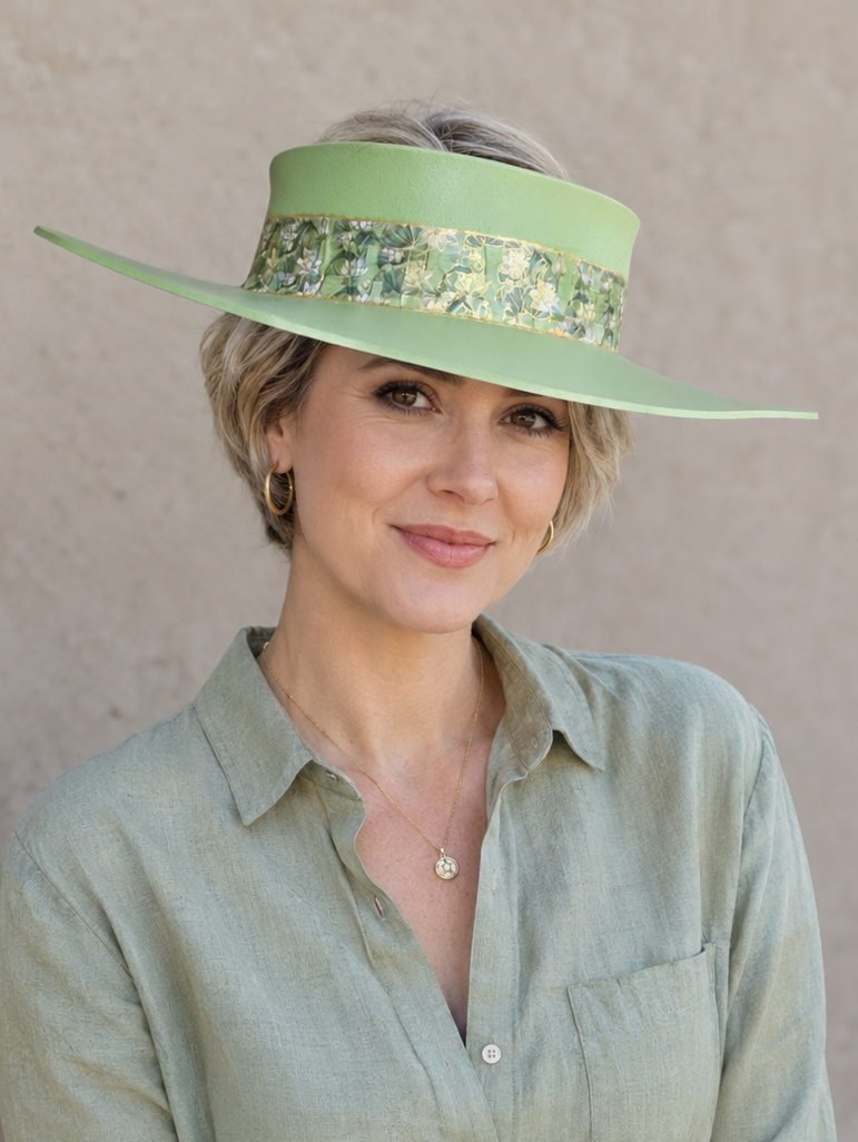 Woman wearing a green hat and shirt against a beige background
