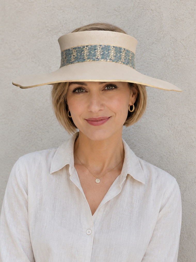 Woman wearing a wide-brimmed hat with a patterned band against a plain background
