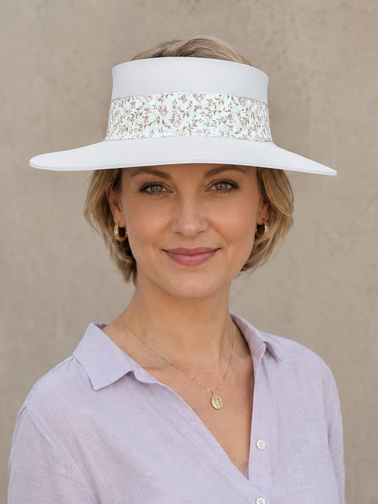 Woman wearing a wide-brimmed hat with a decorative band against a beige background