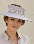 Woman wearing a floral visor against a beige wall