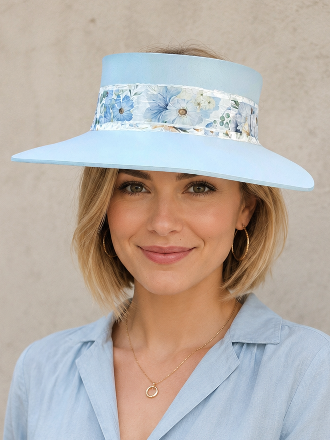 Woman wearing a light blue visor with floral band against a beige background