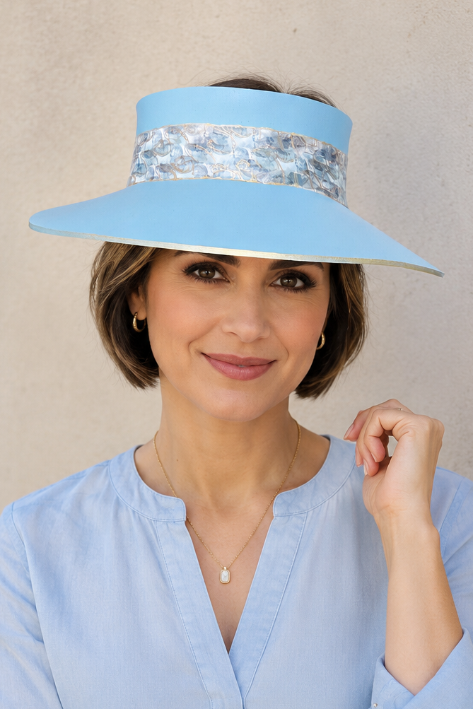 Woman wearing a light blue visor and matching blouse against a beige background