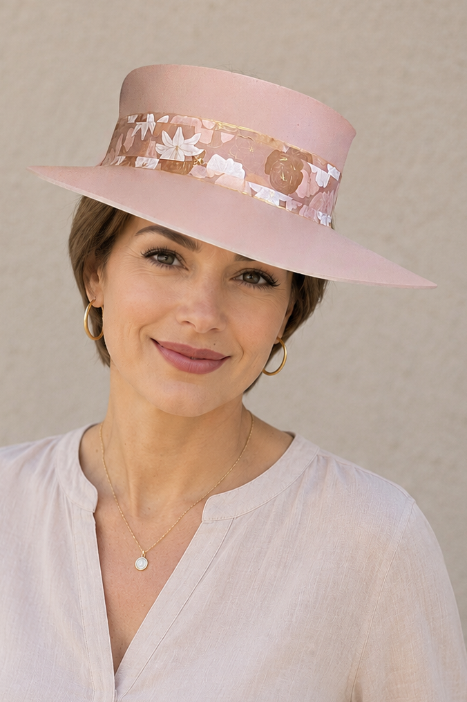 Woman wearing a light pink hat with floral details against a beige background