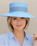 Woman wearing a light blue hat and shirt against a beige background