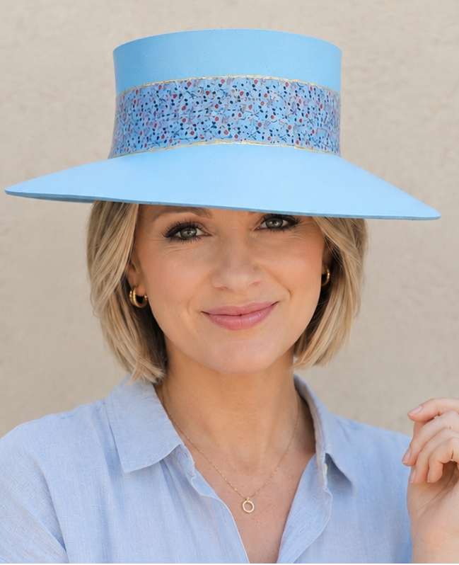 Woman wearing a light blue hat and shirt against a beige background