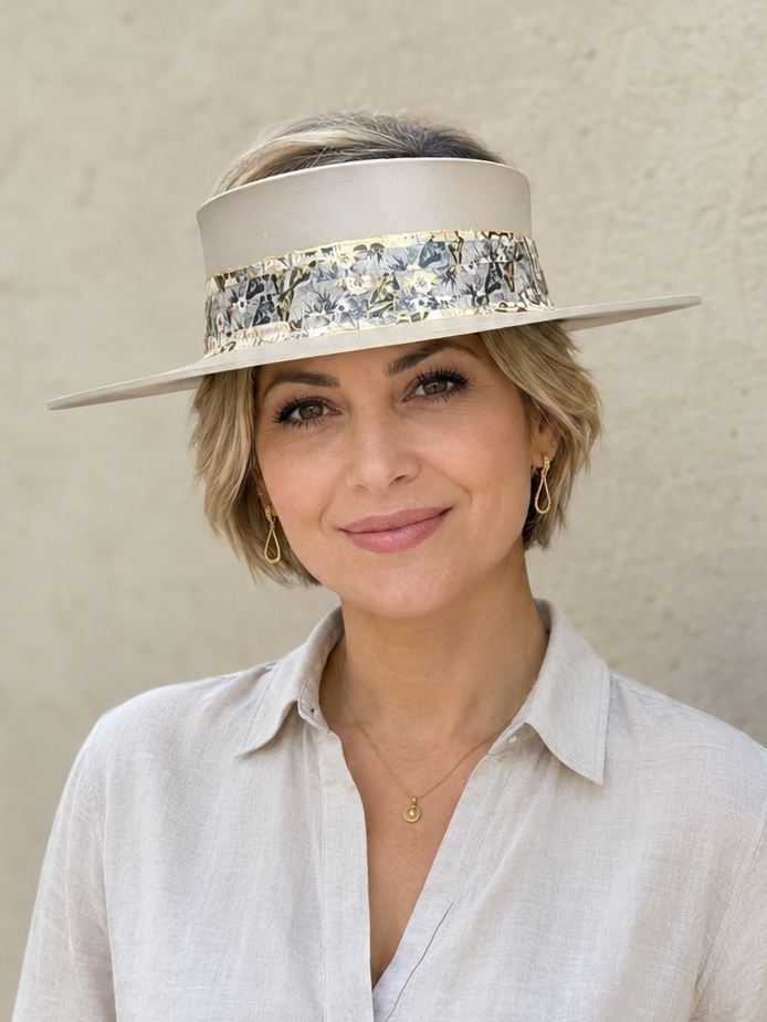 Woman wearing a decorative hat against a plain background