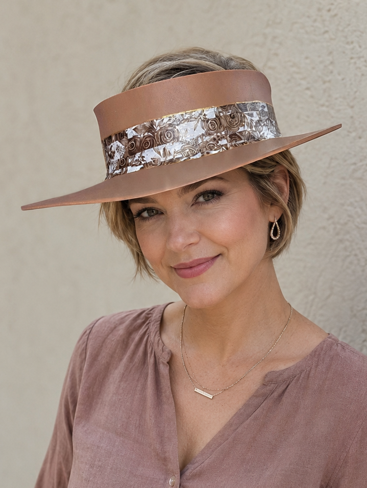 Woman wearing a brown hat with a decorative band against a beige wall