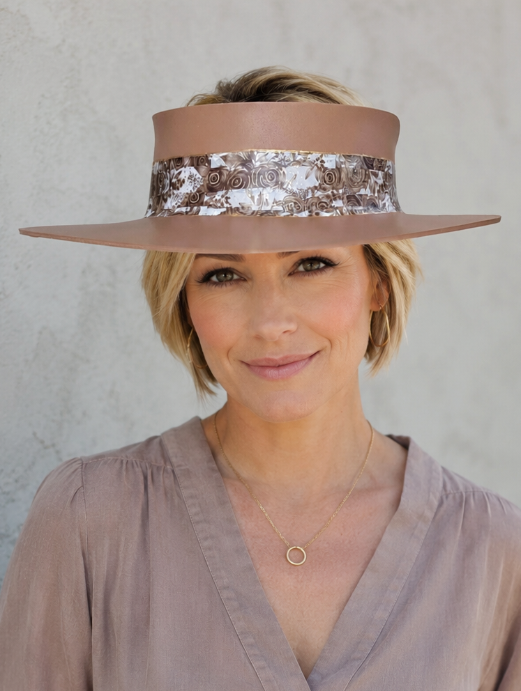Woman wearing a wide-brimmed hat with a sequin band against a plain background