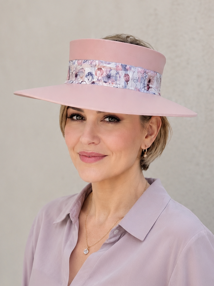 Woman wearing a pink visor with floral band against a plain background