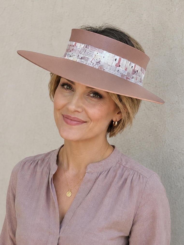 Woman wearing a wide-brimmed visor hat against a plain background
