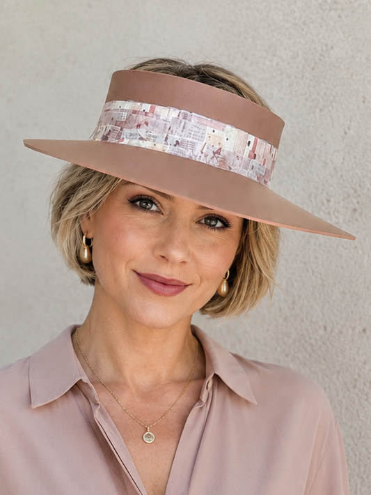 Woman wearing a wide-brimmed hat with a sequin band against a neutral background