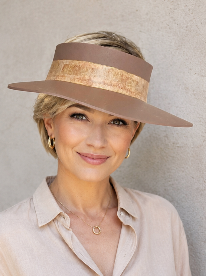 Woman wearing a wide-brimmed hat against a plain background