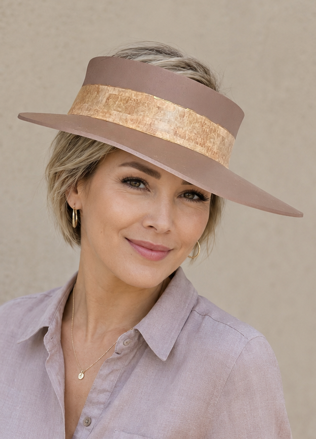 Woman wearing a wide-brimmed hat against a plain background