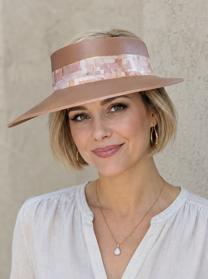 Woman wearing a beige hat and white outfit against a plain background