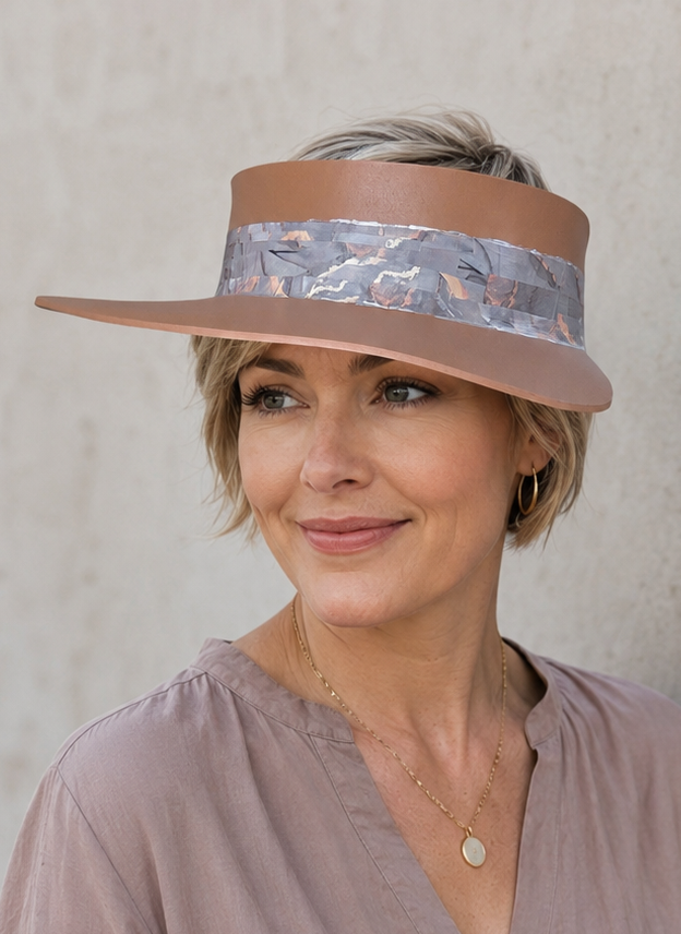 Woman wearing a visor and a long-sleeve shirt against a plain background