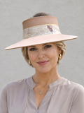 Woman wearing a beige hat with a decorative band against a plain background