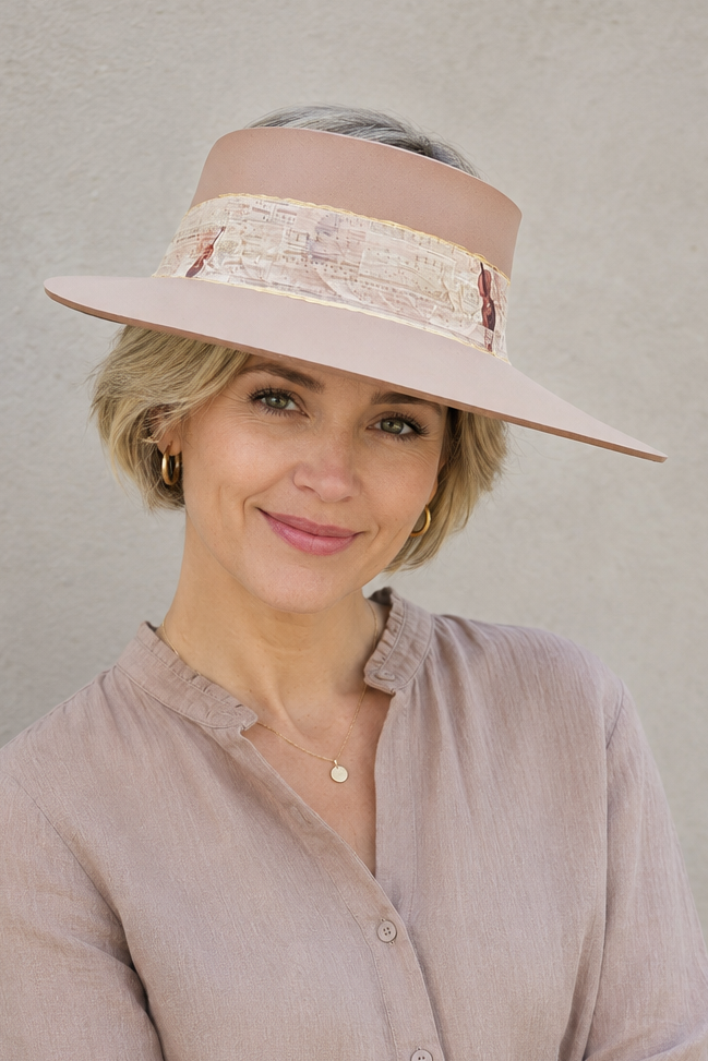 Woman wearing a beige visor hat and light brown shirt against a plain background