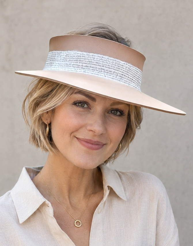 Woman wearing a beige visor and white shirt against a plain background