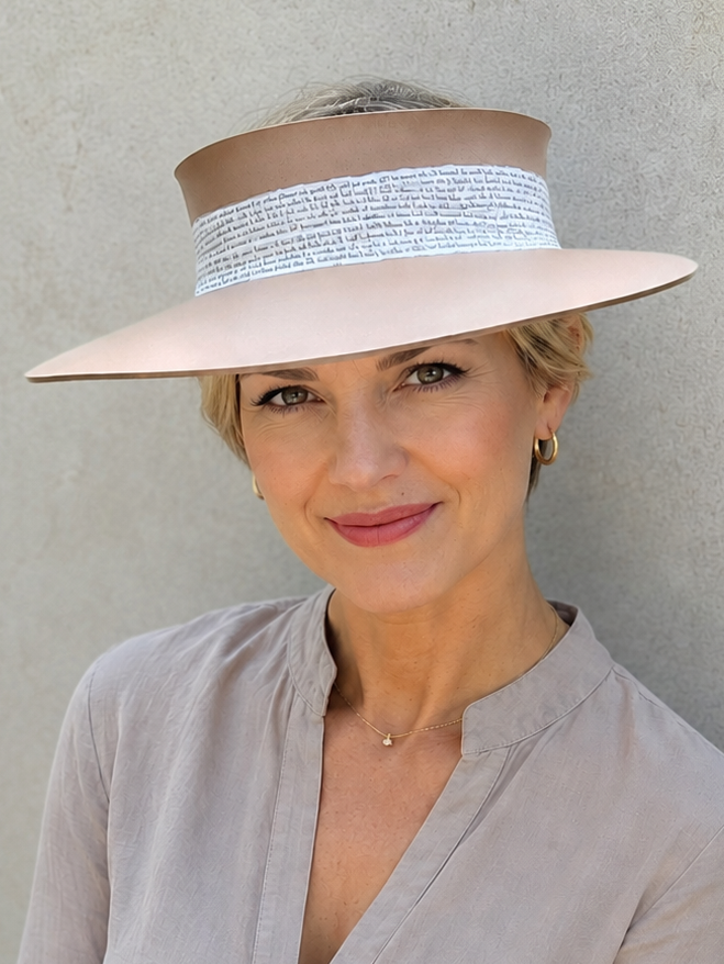Woman wearing a wide-brimmed hat with a neutral background