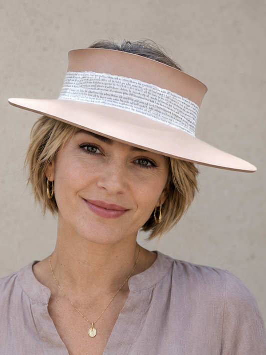 Woman wearing a wide-brimmed hat with a neutral background