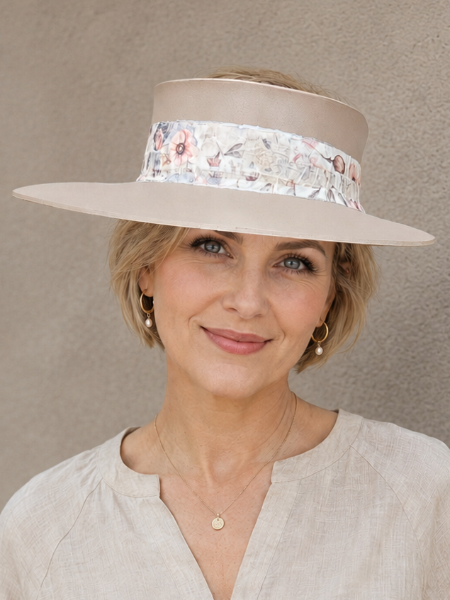 Woman wearing a beige hat with floral band against a plain background