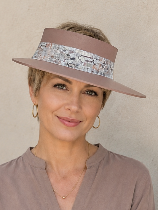 Woman wearing a brown visor and matching blouse against a beige background