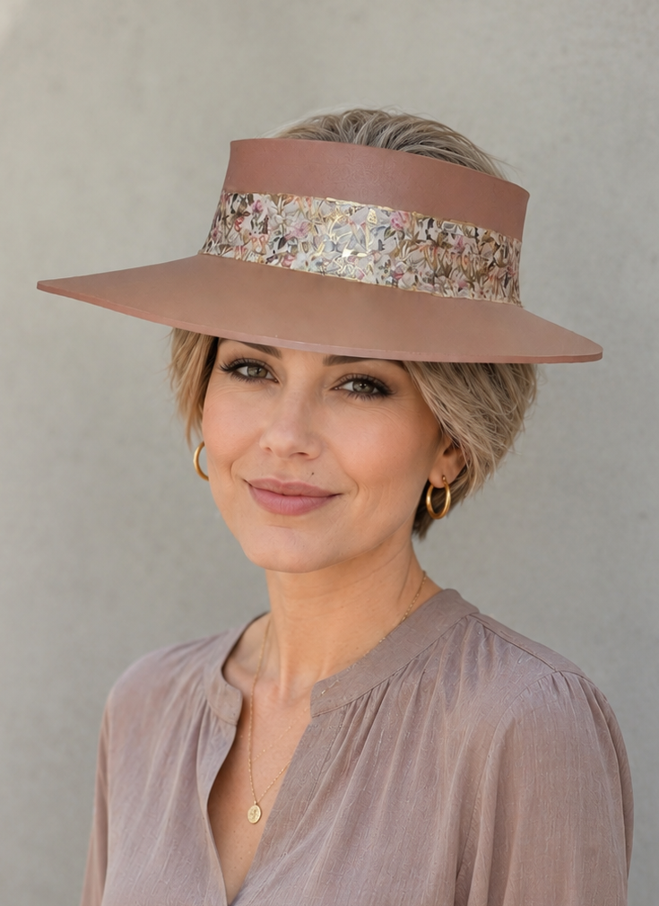 Woman wearing a wide-brimmed hat with decorative band against a plain background