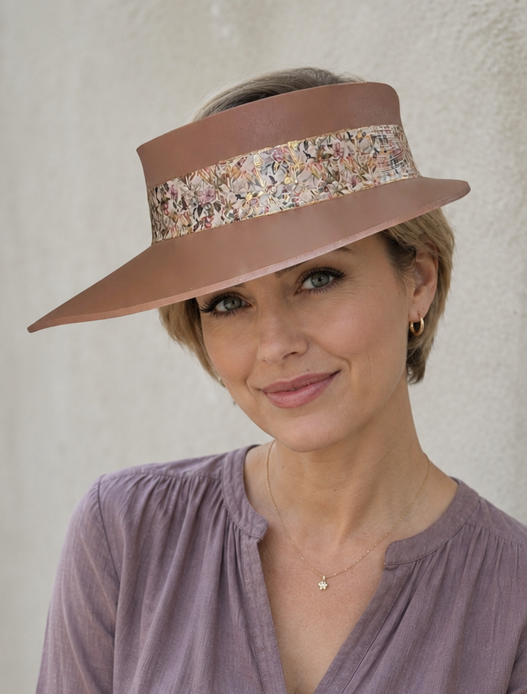 Woman wearing a wide-brimmed hat with a decorative band against a plain background