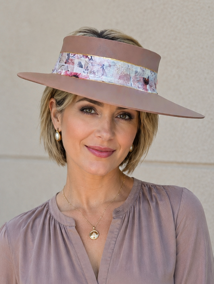 Woman wearing a wide-brimmed hat with floral band against a beige wall