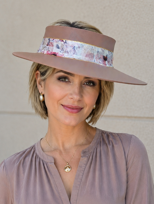 Woman wearing a wide-brimmed hat with floral band against a beige wall