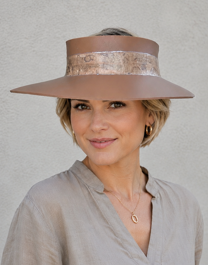Woman wearing a wide-brimmed hat against a plain background
