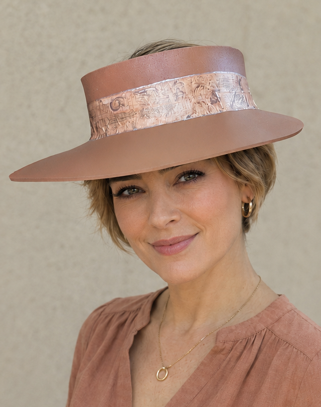Woman wearing a wide-brimmed hat and a brown top against a beige background