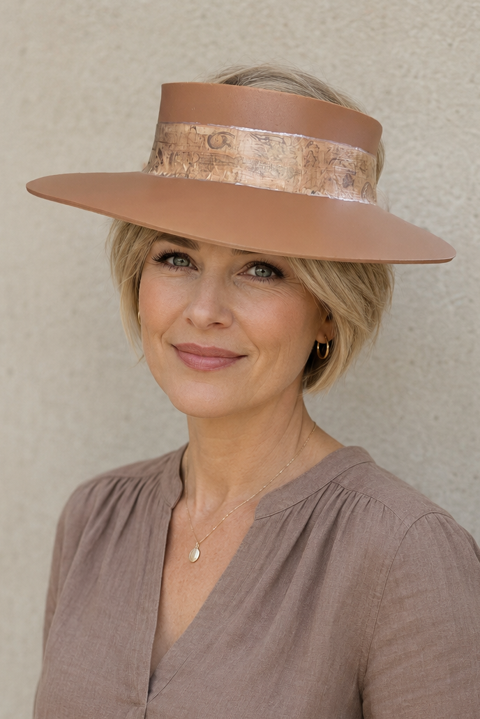 Woman wearing a wide-brimmed hat against a plain background