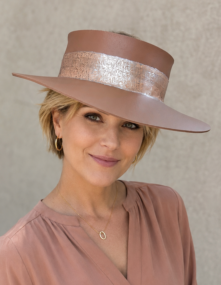 Woman wearing a brown hat and matching blouse against a beige background