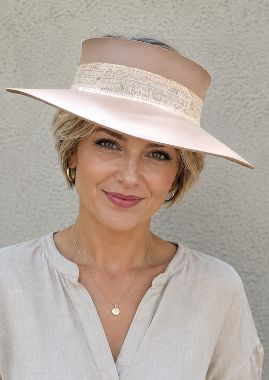 Woman wearing a beige hat and light-colored shirt against a plain background