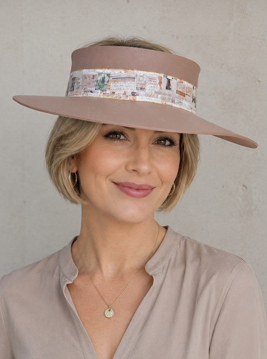 Woman wearing a beige visor and matching blouse against a plain background