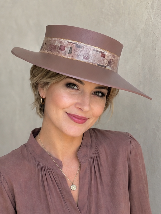 Woman wearing a brown hat and matching blouse against a neutral background