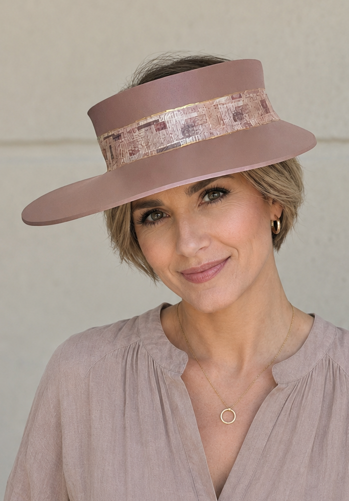Woman wearing a pink hat and matching blouse against a neutral background