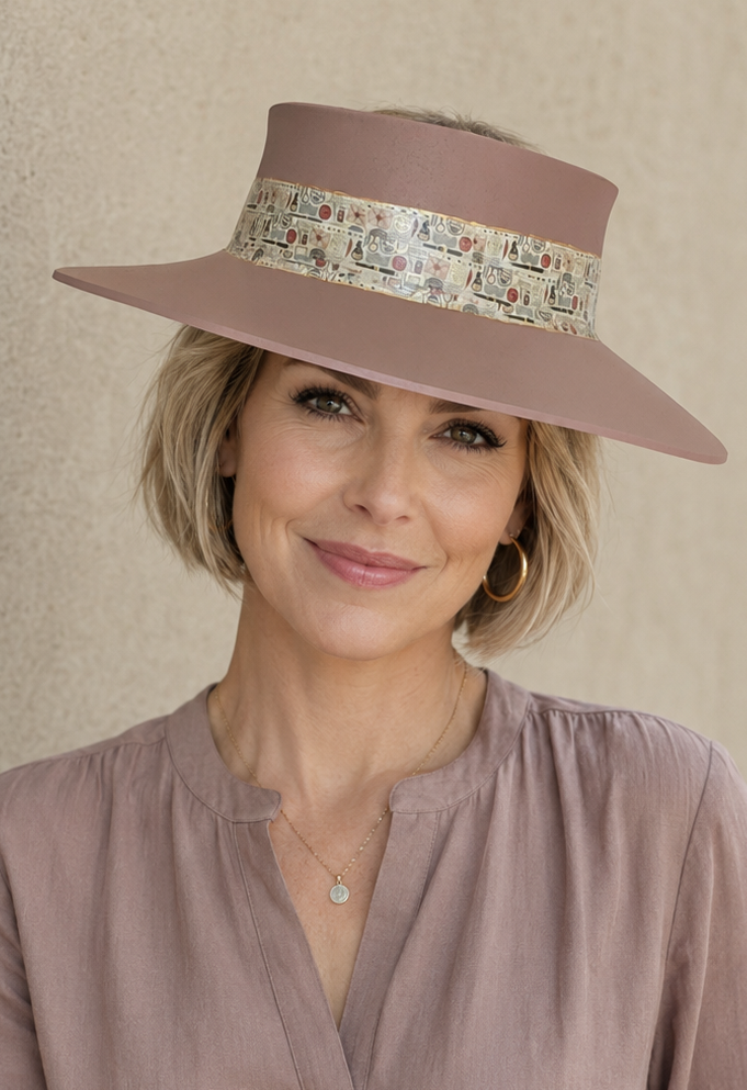 Woman wearing a brown hat with a patterned band against a beige background