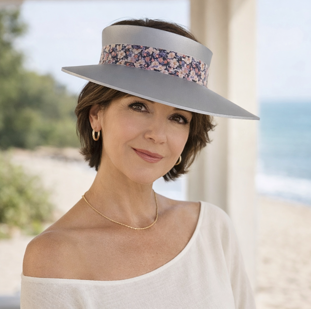Woman wearing a wide-brimmed hat with a floral band, standing outdoors.