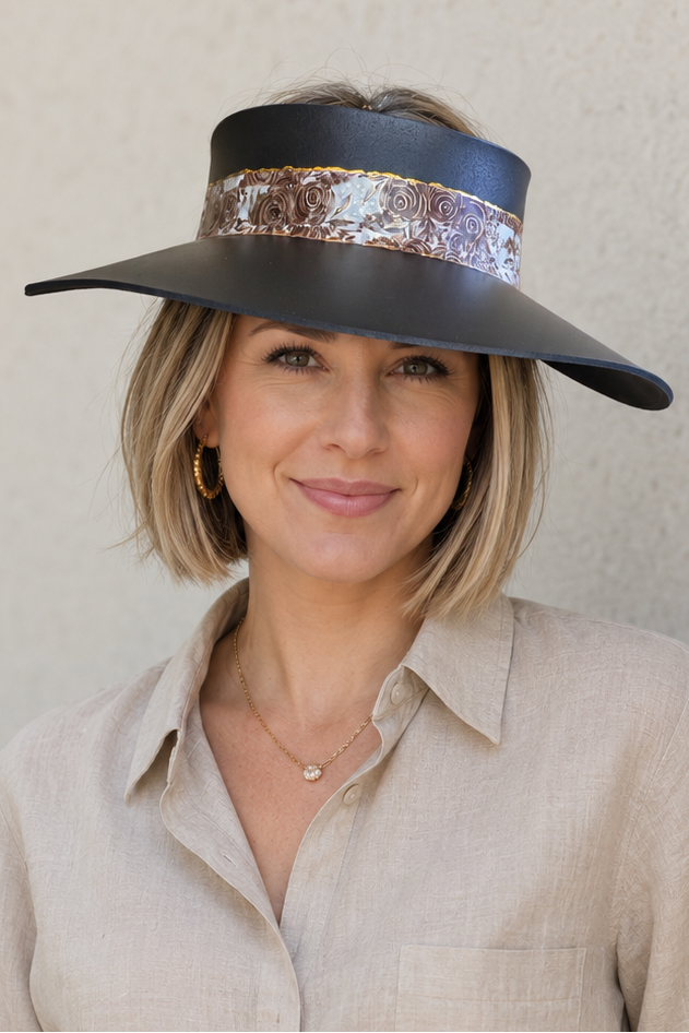 Woman wearing a wide-brimmed hat with a sequin band against a plain background